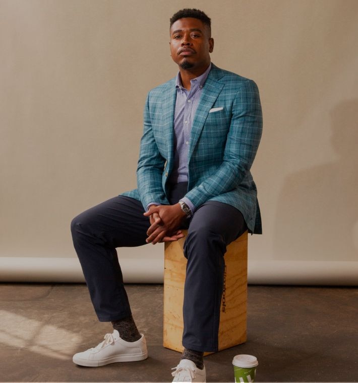 Man in a custom regular fit blue blazer with customized suit pants and dress shirt.