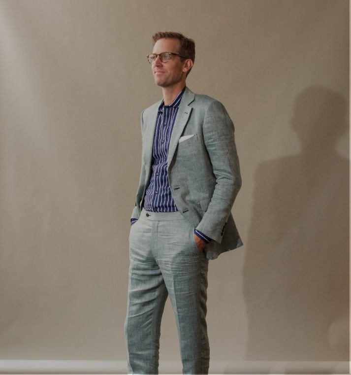 Man in grey tall and slim fit custom-made suit with a dark blue shirt.