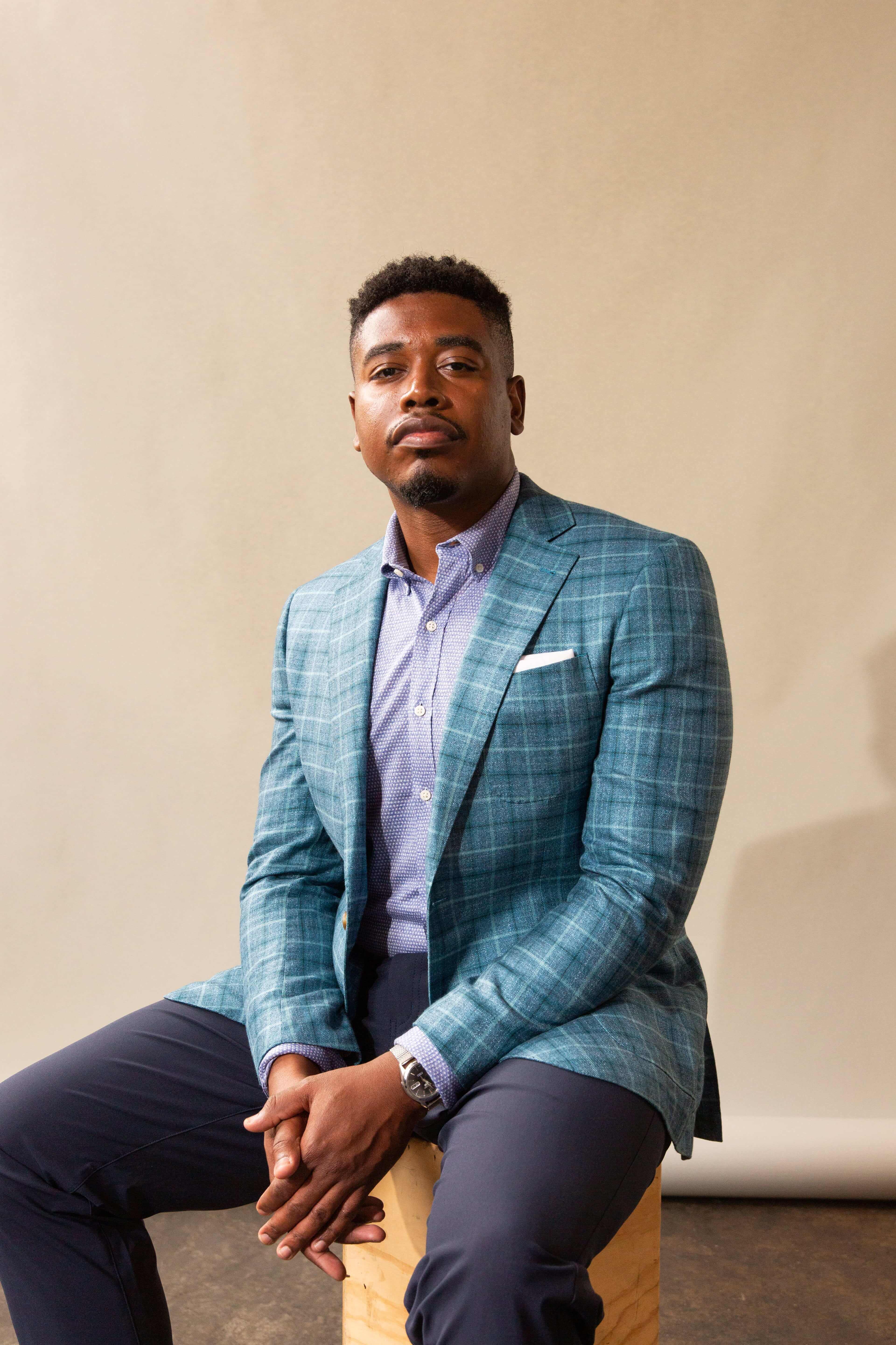 Man in a light blue custom plaid suit jacket and dark blue dress pants